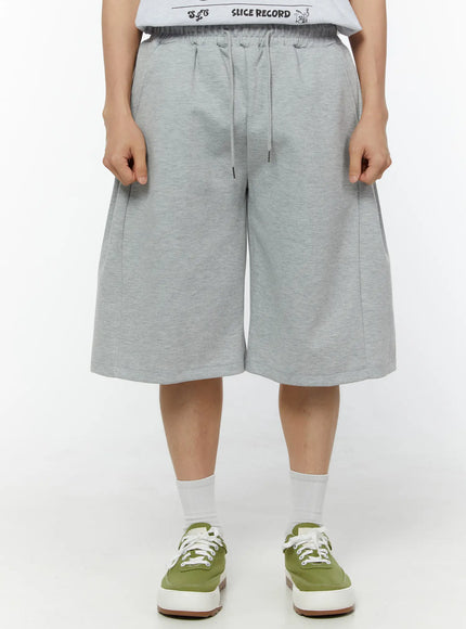 Men's Wide Leg Bermuda Sweat Shorts (Gray) IU529 Gray front view on model standing straight showing drawstring elastic waist wide-leg cut and center seam in heathered cotton fleece