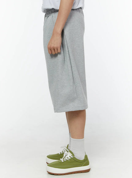 Men's Wide Leg Bermuda Sweat Shorts (Gray) IU529 Gray back view on model showing elastic waistband center back seam and wide-leg hem in heathered cotton fleece styled with green sneakers