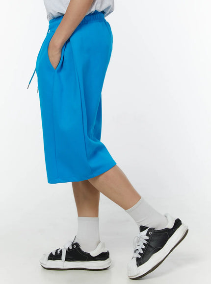 Men's Wide Leg Bermuda Sweat Shorts (Light blue) IU529 Light blue side view on model showing straight wide-leg silhouette elastic waistband with drawstring and smooth fabric texture