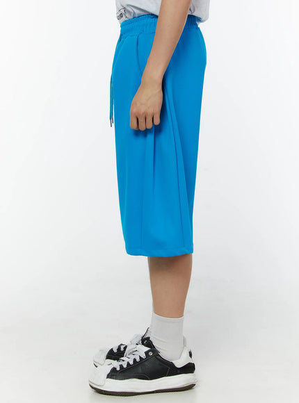 Men's Wide Leg Bermuda Sweat Shorts (Light blue) IU529 Light blue side close-up view on model highlighting drawstring waist side seam detail and relaxed wide-leg cut
