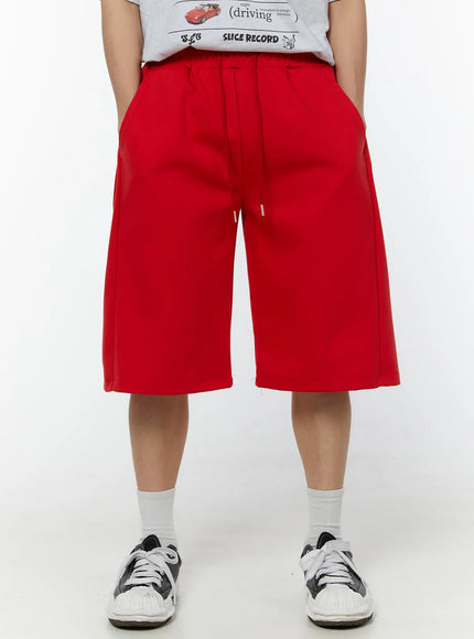 LEWKIN Men's Wide Leg Bermuda Sweat Shorts (Red) IU529 Red front view on model wearing graphic tee and sneakers, wide-leg silhouette with drawstring waist, size M/L