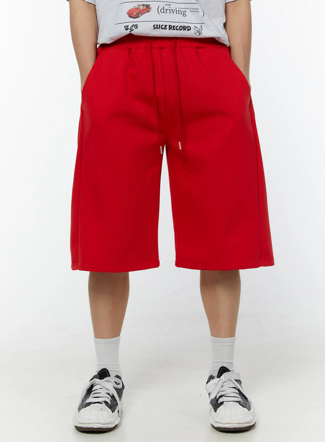 LEWKIN Men's Wide Leg Bermuda Sweat Shorts (Red) IU529 Red front view on model wearing graphic tee and sneakers, wide-leg silhouette with drawstring waist, size M/L