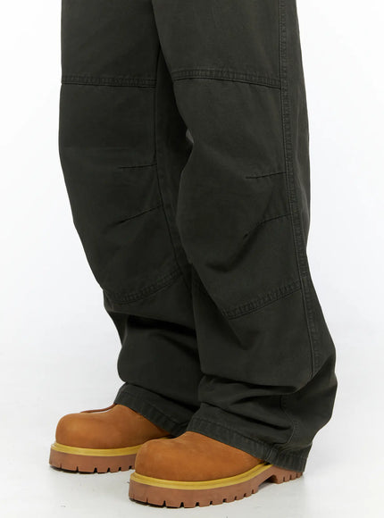 Men's Wide Leg Cargo Pants IL528 dark olive close-up detail of lower leg and hem showing paneled seam construction and wide flare stacking over tan boots