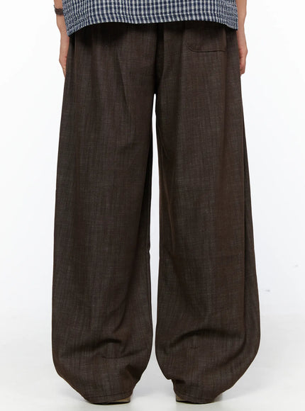 Men's Wide Leg Cotton Pants IL528 Dark brown back close-up on model showing rear waistband with small welt pocket and wide-leg linen-texture fabric