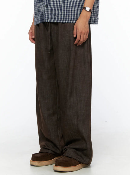 Men's Wide Leg Cotton Pants IL528 Dark brown side close-up on model showing relaxed wide-leg drape and drawstring waist paired with plaid shirt
