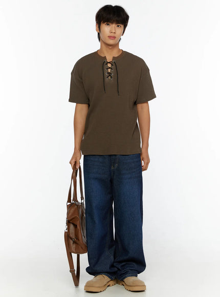 Men's Wide Leg Jeans IL515 dark blue full-body front view on male model wearing brown lace-up waffle tee holding leather bag with beige shoes
