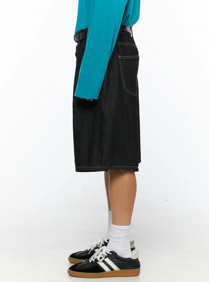 Men's Wide Leg Jorts IL528 Black side view close-up on model showing back pocket, contrast topstitching, and wide-leg hem, styled with teal long-sleeve top