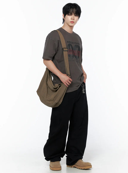 Men's Wide Leg Pants IU523 Black three-quarter front view on male model styled with brown graphic tee and olive canvas crossbody bag