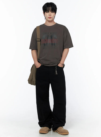 Men's Wide Leg Pants IU523 Black full front view on standing male model styled with brown graphic tee and olive crossbody bag