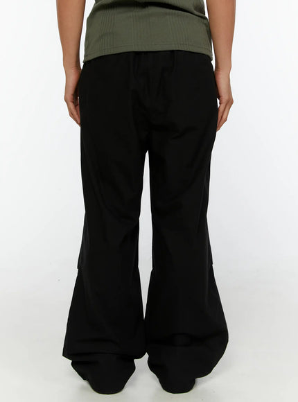 Men's Wide Leg Parachute Pants IL513 Black back shot on model showing rear waistband, wide flared leg, and gathered ankle hem with green tee