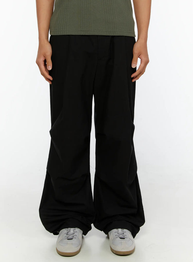 LEWKIN Men's Wide Leg Parachute Pants IL513 Black front crop shot on model wearing green henley tee and white sneakers, wide-leg silhouette with gathered hem