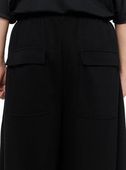 Men's Wide Leg Sweatpants (Black) IL514 black close-up detail of back showing dual flap cargo pockets and wide elastic waistband on model