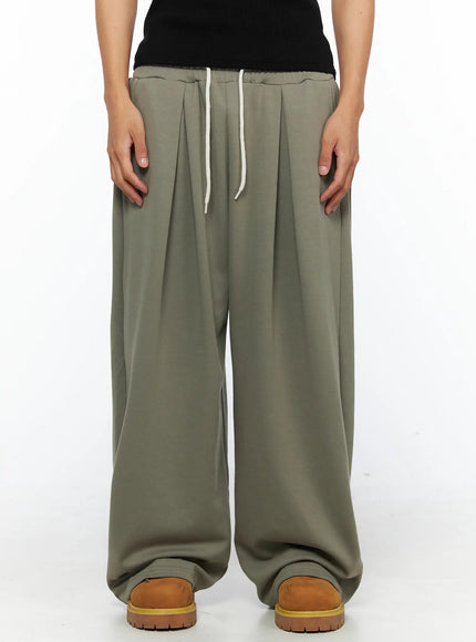 LEWKIN Men's Wide Leg Sweatpants IL528 Dark green front close-up on female model showing pleated waistband with cream drawstring, M/L