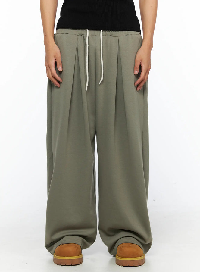 LEWKIN Men's Wide Leg Sweatpants IL528 Dark green front close-up on female model showing pleated waistband with cream drawstring, M/L
