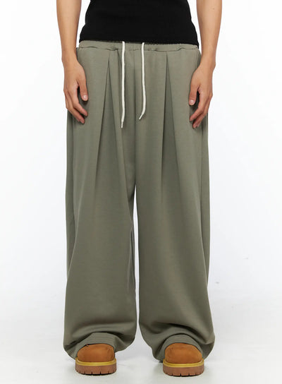 LEWKIN Men's Wide Leg Sweatpants IL528 Dark green front close-up on female model showing pleated waistband with cream drawstring, M/L