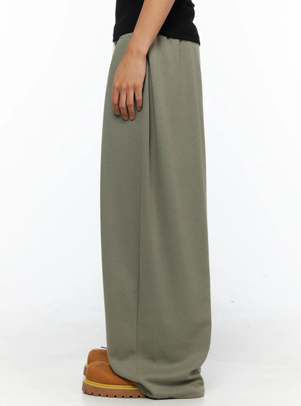 Men's Wide Leg Sweatpants IL528 Dark green back shot on female model showing wide-leg drape, elastic waistband, and voluminous hem pooling at floor