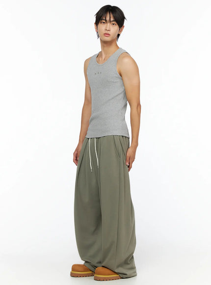 Men's Wide Leg Sweatpants IL528 Dark green front full-body shot on male model wearing grey ribbed tank, hands at sides, standing straight