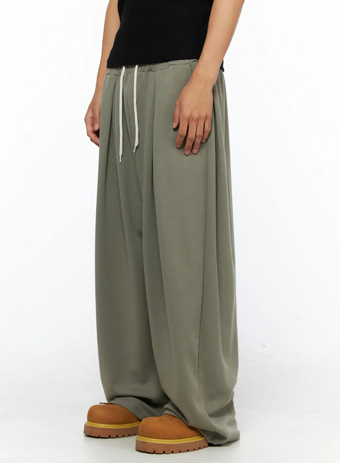 Men's Wide Leg Sweatpants IL528 Dark green side shot on male model styled with grey ribbed tank top and tan chunky shoes, angled pose