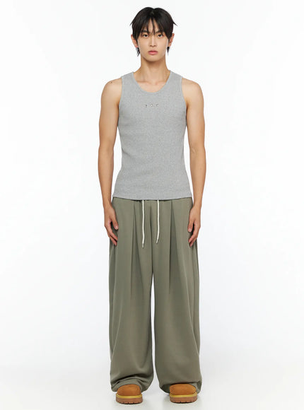 Men's Wide Leg Sweatpants IL528 Dark green side shot on female model showing full-length straight silhouette, elastic waistband, and tan chunky sandals