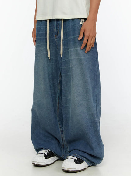 Men's Wide Leg Tie-Detail Jeans IL513 Blue side close-up on model highlighting wide balloon leg silhouette and cream drawstring waistband with brand patch