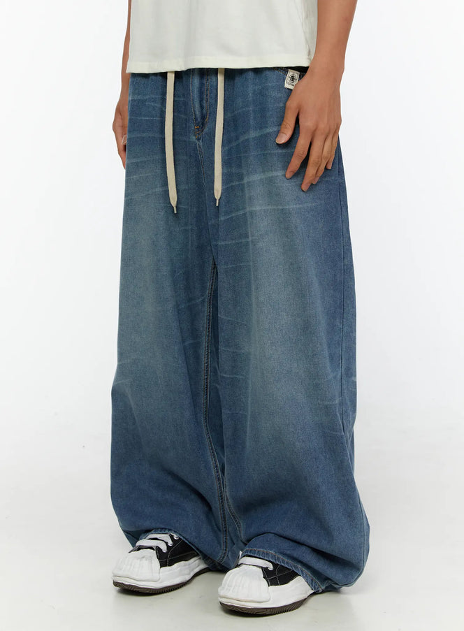 Men's Wide Leg Tie-Detail Jeans IL513 Blue side close-up on model highlighting wide balloon leg silhouette and cream drawstring waistband with brand patch