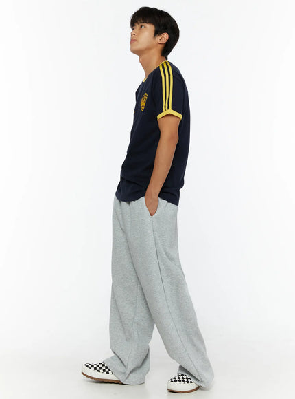 Men's Wide Sweatpants (Gray) IL507 Gray side view on male model looking upward with hand in pocket showing relaxed wide-leg silhouette and pintuck crease in heathered gray fleece
