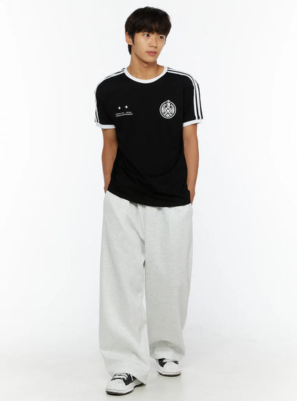 Men's Wide Sweatpants (Light Gray) IL507 Light gray full-body front shot on male model facing slightly right, styled with black stripe tee and sneakers