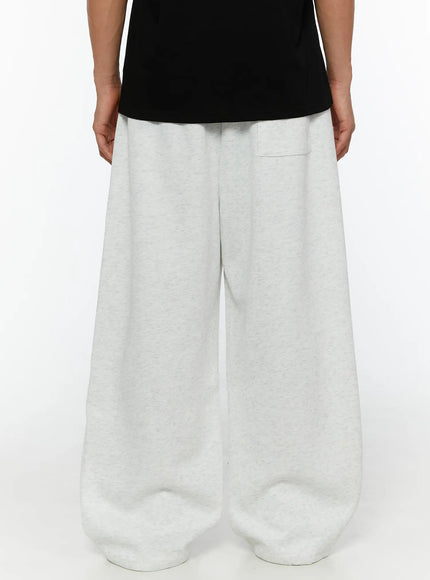 Men's Wide Sweatpants (Light Gray) IL507 Light gray back shot on model showing elastic waistband, back patch pocket, and wide-leg heathered fleece fabric