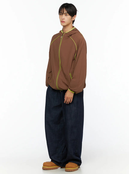 Men's Zack Wide Leg Jeans IL528 Dark blue three-quarter side view on male model in brown neon-trim zip hoodie and tan boots, wide balloon denim leg silhouette