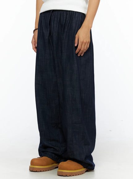 Men's Zack Wide Leg Jeans IL528 Dark blue side view on model showing elastic waistband detail, drawstring tie, and wide-leg denim silhouette with chunky boots