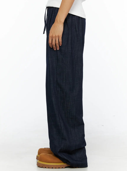 Men's Zack Wide Leg Jeans IL528 Dark blue side view close-up on model showing drawstring elastic waist and straight wide-leg denim drape with chunky tan boots