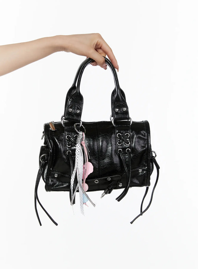 LEWKIN Metallic Detail Shoulder Bag CL508 Black front view held aloft by model's hand showing crinkled faux leather with silver hardware and pink charm tassel