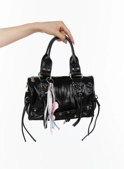 LEWKIN Metallic Detail Shoulder Bag CL508 Black front view held aloft by model's hand showing crinkled faux leather with silver hardware and pink charm tassel