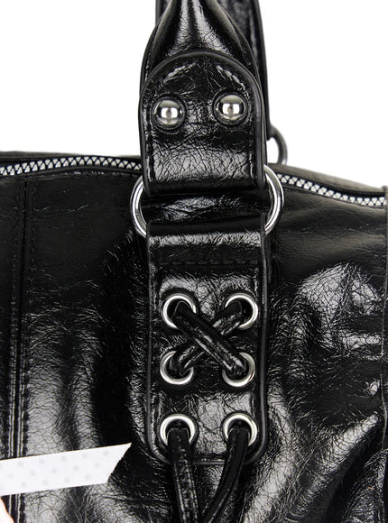 Metallic Detail Shoulder Bag CL508 Black close-up detail of side zipper silver pull and ring eyelet hardware on glossy crinkled faux leather texture