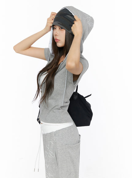 Military Style Beanie IL515 Dark gray side shot on model adjusting beanie over hood of gray zip-up hoodie styled with sweatpants and black bag