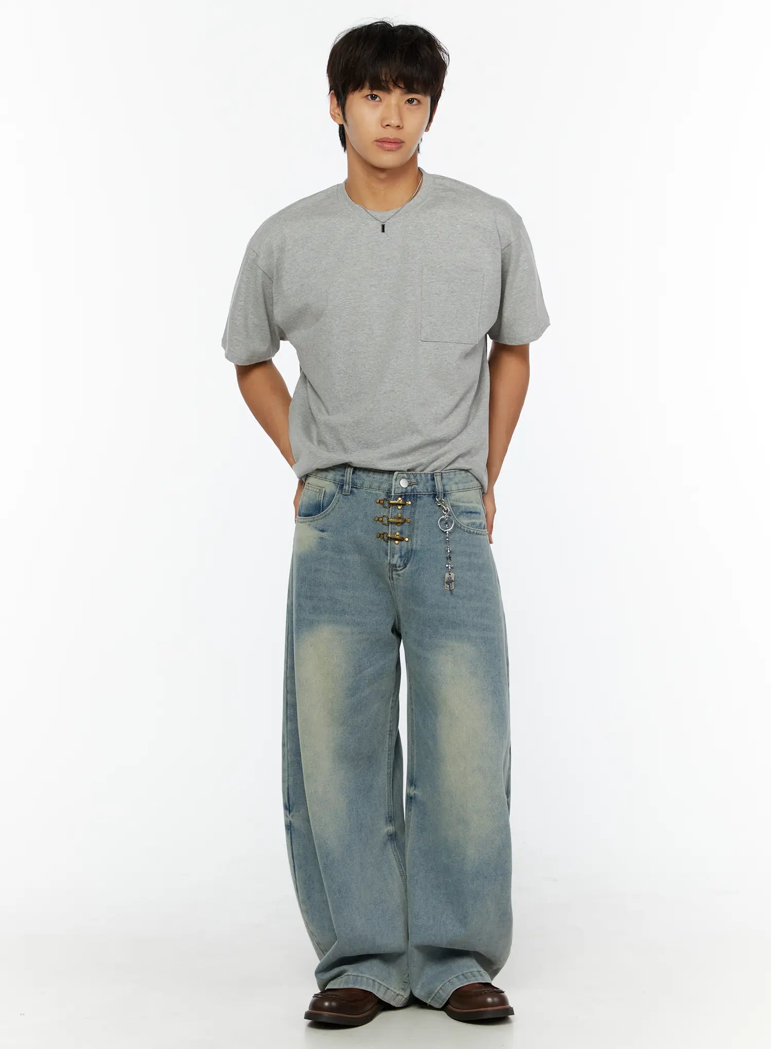 Minimal Tag Necklace IL507 Silver front full-body model shot male model in grey tee and wide-leg jeans hand raised to neck silver tag necklace visible