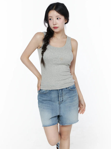Minimalist Slim-Fit Tank Top IU525 Gray front view on model looking aside with braided hair, fitted ribbed scoop neck tank styled with denim shorts, casual pose