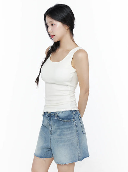 Minimalist Slim-Fit Tank Top IU525 White side profile view on model looking away, slim-fit scoop neck ribbed tank with denim shorts, braided hair