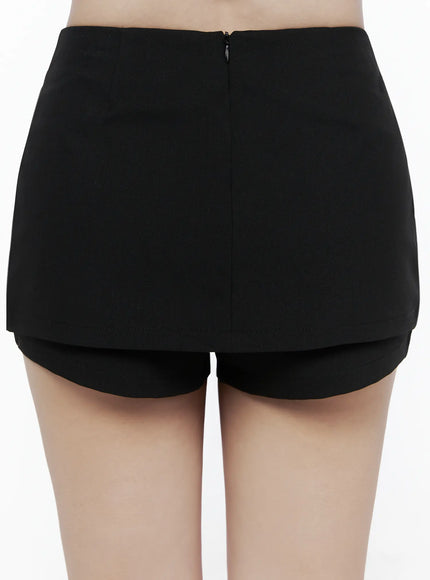 Minimalist Wrap Mini Skort IU525 Black back close-up on model showing center zip closure and clean layered hem of built-in shorts