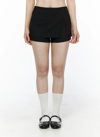LEWKIN Minimalist Wrap Mini Skort IU525 Black Size S front close-up on model standing straight showing layered skort with asymmetric pleat detail