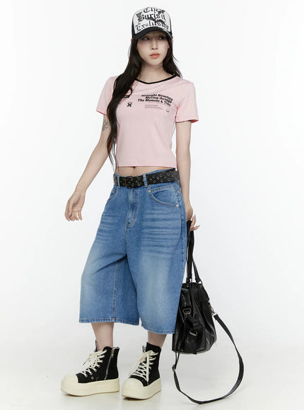 Miu Wide Leg Jeans IL521 Blue full-body front shot on model with graphic trucker cap leather shoulder bag and black belt standing straight in street style outfit