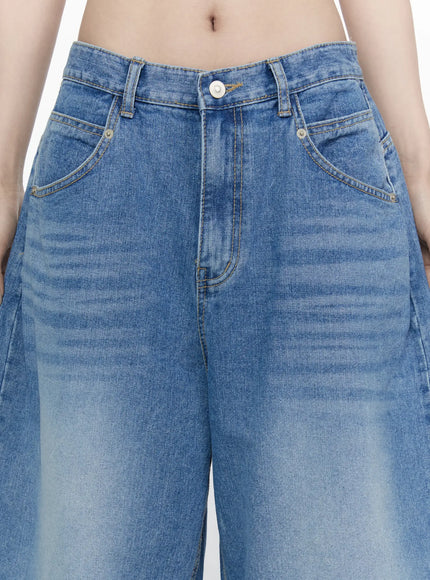Miu Wide Leg Jeans IL521 Blue close-up detail shot on model showing waistband button fly front pockets and washed blue denim texture