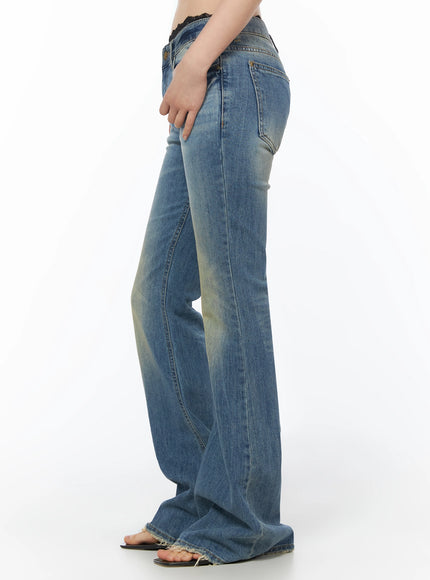 Moira Washed Low-Rise Bootcut Jeans IL502 Blue side cropped waist-to-ankle view on model, hand resting on hip, back pocket and side seam detail visible, raw frayed hem at floor