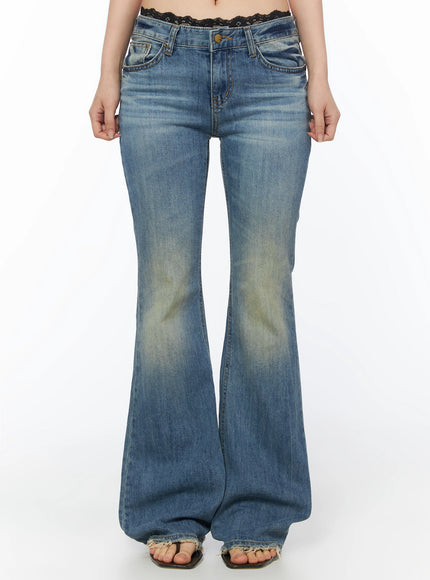 LEWKIN Moira Washed Low-Rise Bootcut Jeans IL502 Blue front view on model, cropped shot from waist down, flared hem with frayed edge, washed denim texture, lace waistband peeking above
