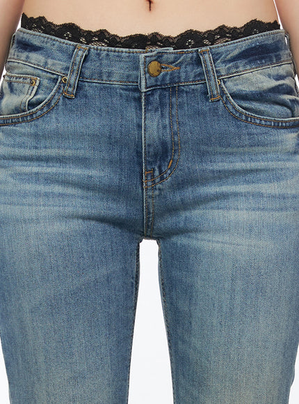 Moira Washed Low-Rise Bootcut Jeans IL502 Blue close-up front detail of waistband and fly, brass button, contrast stitching, lace trim visible above waistband, washed denim texture