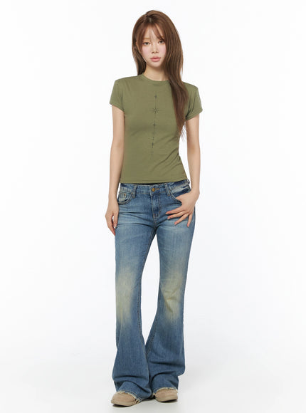 Moira Washed Low-Rise Bootcut Jeans IL502 Blue full-body front view on model standing upright, styled with olive green star-print crop tee and beige sneakers, white background