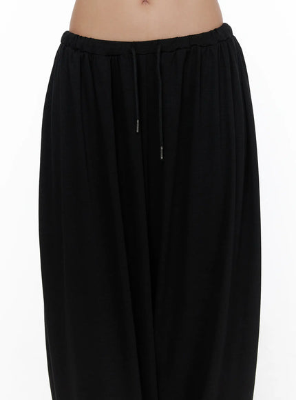 Multi-Purpose Balloon Sweatpants CL513 Black close-up detail shot of elastic drawstring waistband with silver aglet tips on model