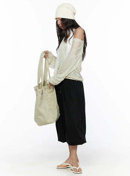 Multi-Purpose Balloon Sweatpants CL513 Black side shot on model looking down while holding tote bag styled with beige off-shoulder top and sandals