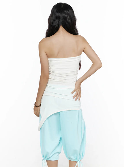 Multifunctional Ruched Sleeveless Top CL513 White back shot on model revealing strapless back, ruched texture and asymmetric hem detail over light blue gathered balloon pants