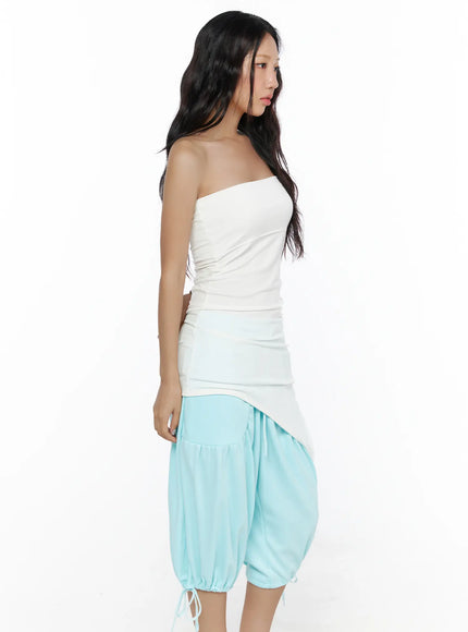 Multifunctional Ruched Sleeveless Top CL513 White side shot on model showing ruched side seam and smooth stretch fabric of strapless top paired with light blue balloon crop pants